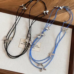 Minimalist layered beaded necklace with textured silver butterfly charms in black and blue