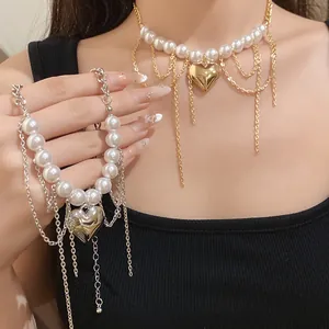 Detailed macro view of gold and silver heart pearl necklaces with dangling chain tassels