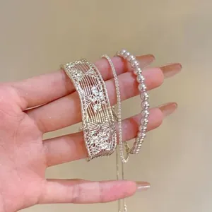Detail view of silver hollow cuff bracelet with pearl and rhinestone strands