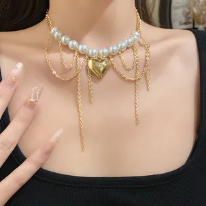 Close-up of elegant pearl necklace with gold heart pendant and layered chains