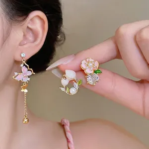 Boucles d'oreilles asymétriques papillon et fleur avec émail rose et perles douces