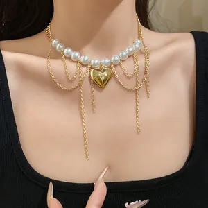 Close-up of vintage pearl beaded choker with gold heart pendant and tassel chains