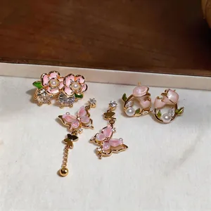 Collection de puces d'oreilles fleurs roses et boucles papillon asymétriques en doré