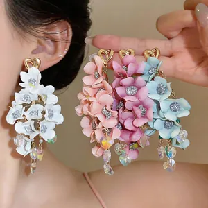 Macro view of colorful fabric flower tassel earrings with shimmering crystal heart drops