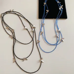 Detailed layout of black and blue beaded necklaces featuring silver textured butterfly charms