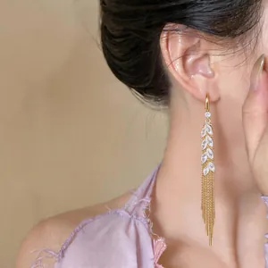 Close-up detail showing the elegant 18k gold plated wheat tassel earrings with sparkling zirconia