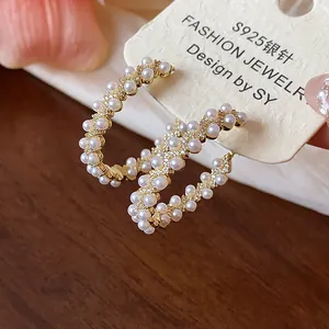 Detail showing 14k gold plated hoop earrings decorated with elegant pearl clusters