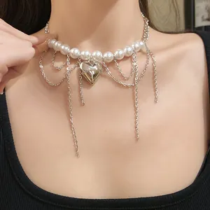 Detailed view of pearl beaded choker with silver heart pendant and chain tassels