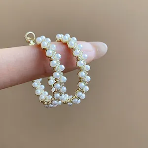 Detailed close-up of elegant 14k gold plated hoop earrings featuring double-row pearls and CZ