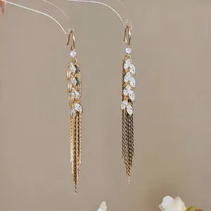Detailed macro view of 18k gold plated wheat spike tassel earrings with sparkling cubic zirconia