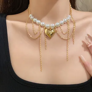 Close-up view of pearl bead chain necklace with gold heart pendant and tassel chains