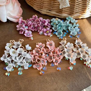 Detailed display of handmade floral dangle earrings featuring iridescent heart-shaped crystal charms