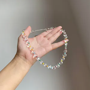 Detailed shot of clear icy heart bead necklace with colorful spacers held in hand