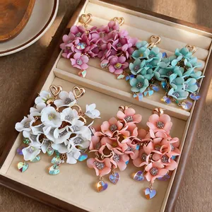 Close-up of elegant fabric flower earrings with heart crystal drops in a jewelry box