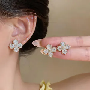 Detailed view of 18K gold plated flower earrings set with sparkling zirconia stones.