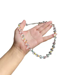 Clear heart beaded necklace with colorful accent beads, held in hand for scale.
