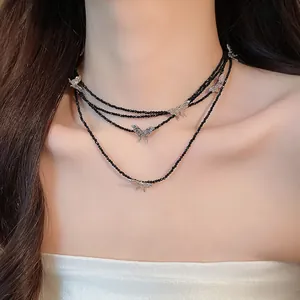 Elegant close-up of a multi-layer black beaded necklace featuring silver butterfly pendants