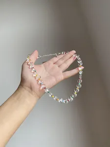Close-up detail of a transparent heart-shaped beaded necklace with colorful rainbow accents