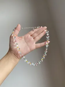 Macro view of a clear heart beaded necklace with vibrant rainbow accent beads