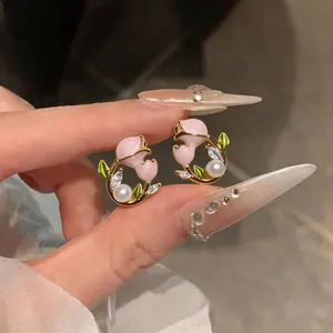 Vue détaillée des boucles d'oreilles tulipes roses avec perles et cristaux brillants
