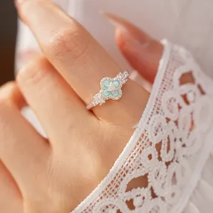 Nahaufnahme eines silbernen Rings mit hellgrünem Zirkon-Vierklee-Design für Damen
