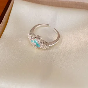 Makro-Detail des blauen Zirkon-Kleeblatt-Designs dieses silberfarbenen offenen Rings