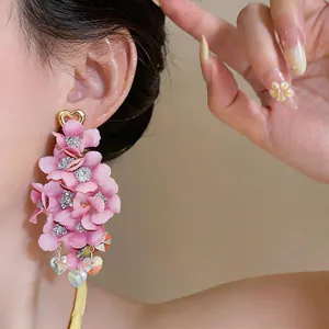 Detail view showing exquisite pink fabric flower tassel earrings with golden heart studs