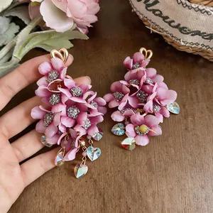 Detailed macro shot of pink fabric flower drop earrings with iridescent heart crystals
