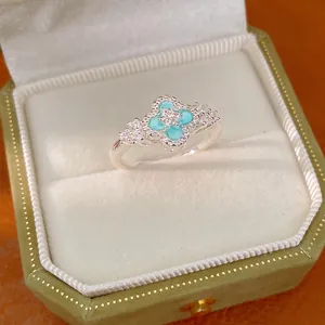 Detaillierte Ansicht eines Kleeblatt-Rings mit blauem Zirkon in einer grünen Samtschachtel.