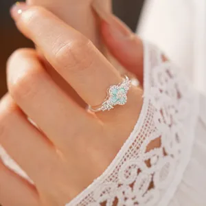 Detailaufnahme eines silbernen Kleeblattrings mit blauer Einlage und glitzernden Zirkonia
