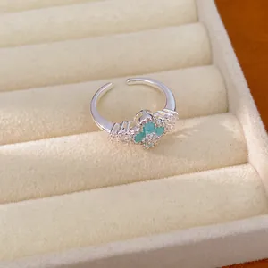 Nahaufnahme eines silbernen offenen Rings mit türkisem Kleeblatt und Zirkonia-Details