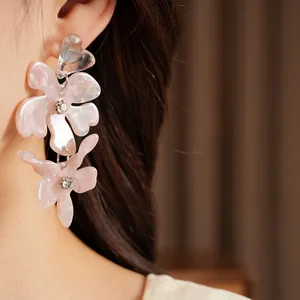 Close-up detail of elegant resin flower tassel earrings featuring sparkling rhinestones