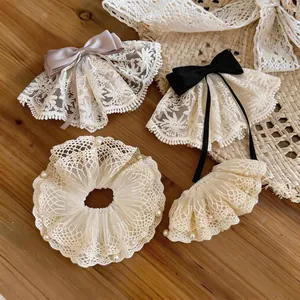 Elegante Haarklammern und Haargummis aus Spitze und Perlen auf Holzgrund