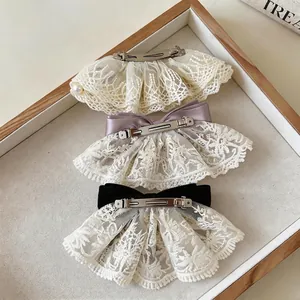Set aus drei eleganten Spitzen-Haarspangen mit Satinschleifen und Perlendetails auf Tablett.
