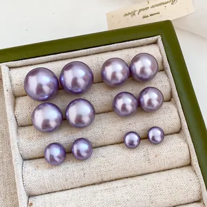 Detail view of 18K gold plated purple pearl stud earrings in multiple sizes