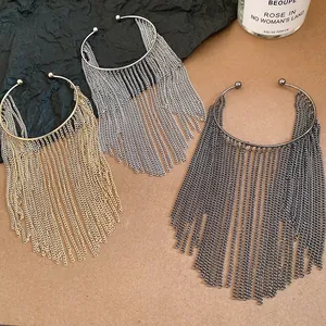 Detailed macro view of three metallic fringe chain cuff bracelets in gold silver and black