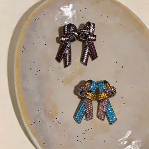 Élégantes boucles d'oreilles nœud papillon avec strass colorés, finition vintage.