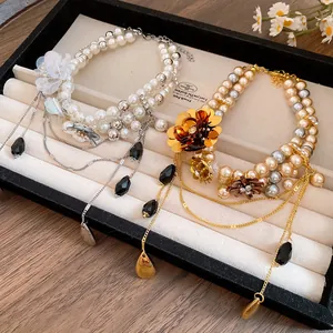 Vue détaillée de colliers de perles vintage avec fleur en strass et breloques noires