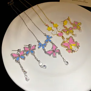 Detail view of butterfly necklace and earring set with colorful enamel and crystals