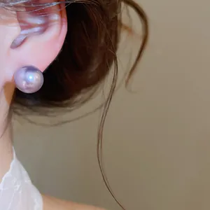 Close-up detail of a large purple pearl stud earring worn on an ear with 18K gold plating.