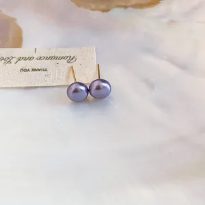 Detailed close-up of elegant purple pearl stud earrings with 18K gold plated posts