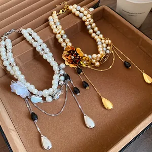 Gros plan détaillé de colliers en perles vintage double rang avec breloques de fleurs