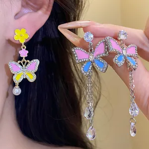 Close-up of color-contrast butterfly earrings with rhinestones and elegant tassels