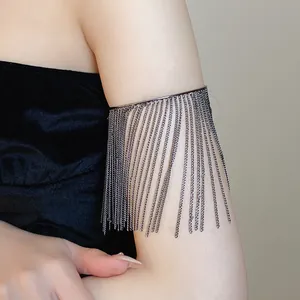 Close-up of gunmetal metal tassel arm cuff with long flowing chains on upper arm