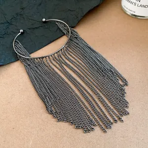 Close-up detail of vintage gunmetal open cuff bracelet with long cascading metal chain fringes