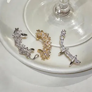 Lot de trois ear cuffs en zircon aux motifs floraux et géométriques pour oreilles.
