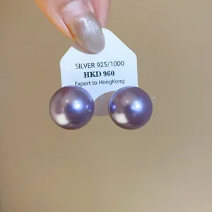 Macro view of elegant large purple pearl stud earrings presented on a silver 925 card holder