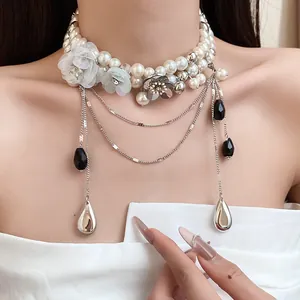 Vue détaillée du collier ras-du-cou en perles vintage avec fleurs en tissu et en métal