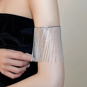 Close-up detail of a silver metal fringe tassel armlet worn on a model's arm