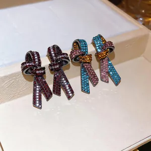 Vue détaillée de boucles d'oreilles nœud luxueuses ornées de cristaux en divers coloris tendance